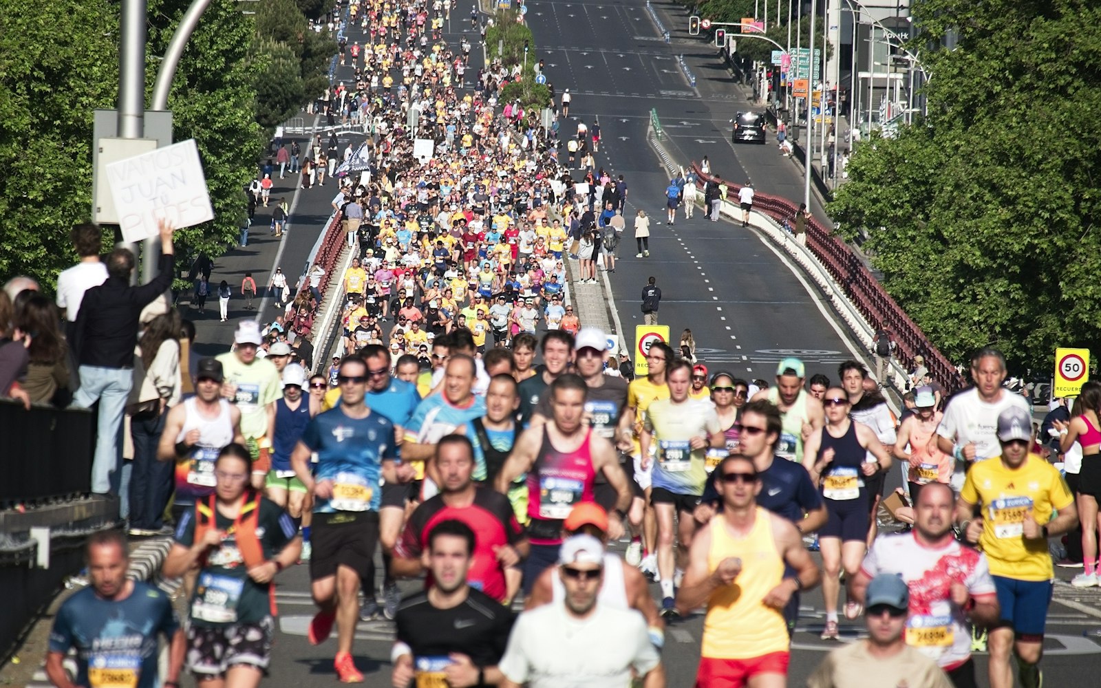 Runners packing a city street at the start of a marathon